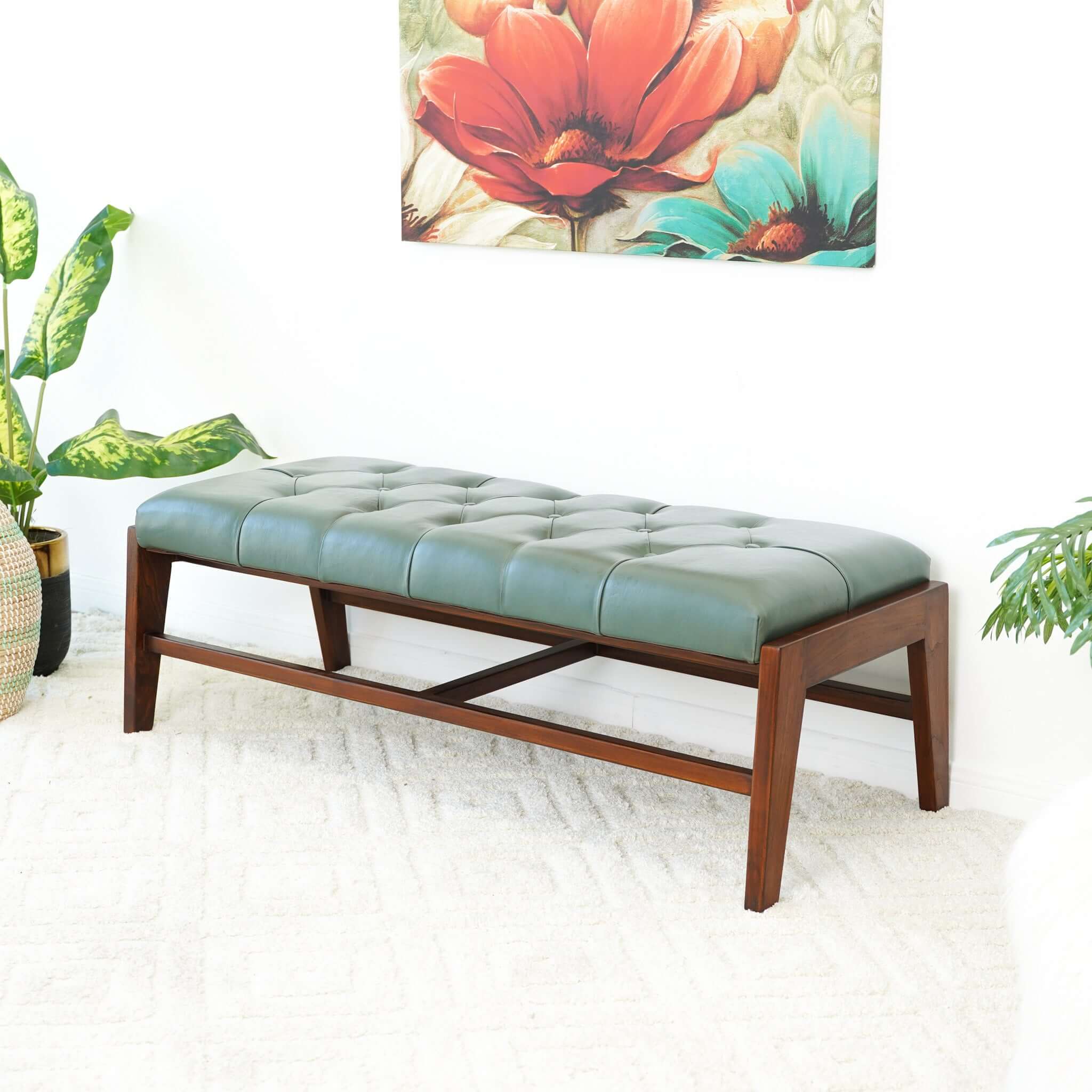 A green leather bench with button detailing, set on a solid walnut wood frame.